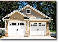 A beige two-car garage with white doors and stone accents.