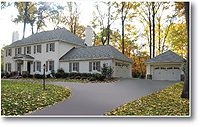 A spacious suburban house with a large driveway and garage.