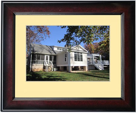 Framed photo of a white house with a porch and green lawn.