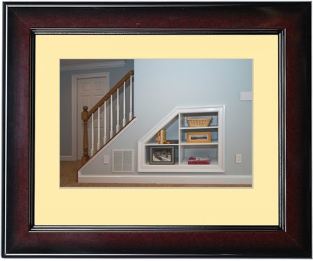 Framed artwork of a staircase with built-in bookshelf under the stairs.