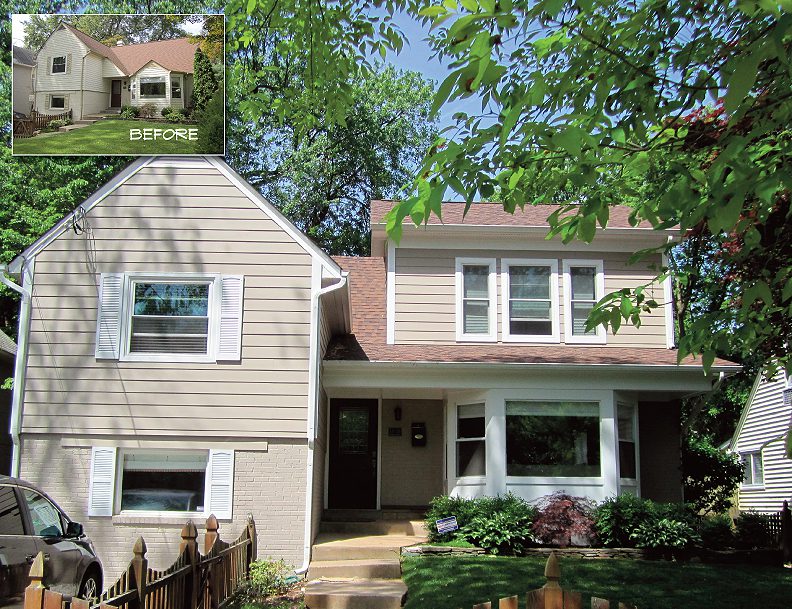 Two-story beige house with white trim and greenery.