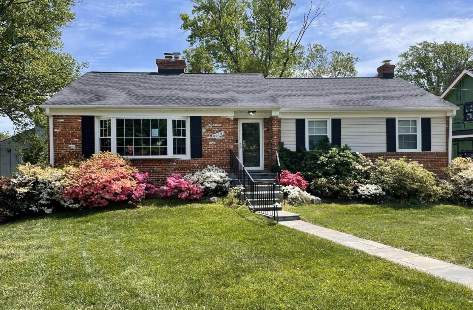 Single-story brick house with flowering shrubs