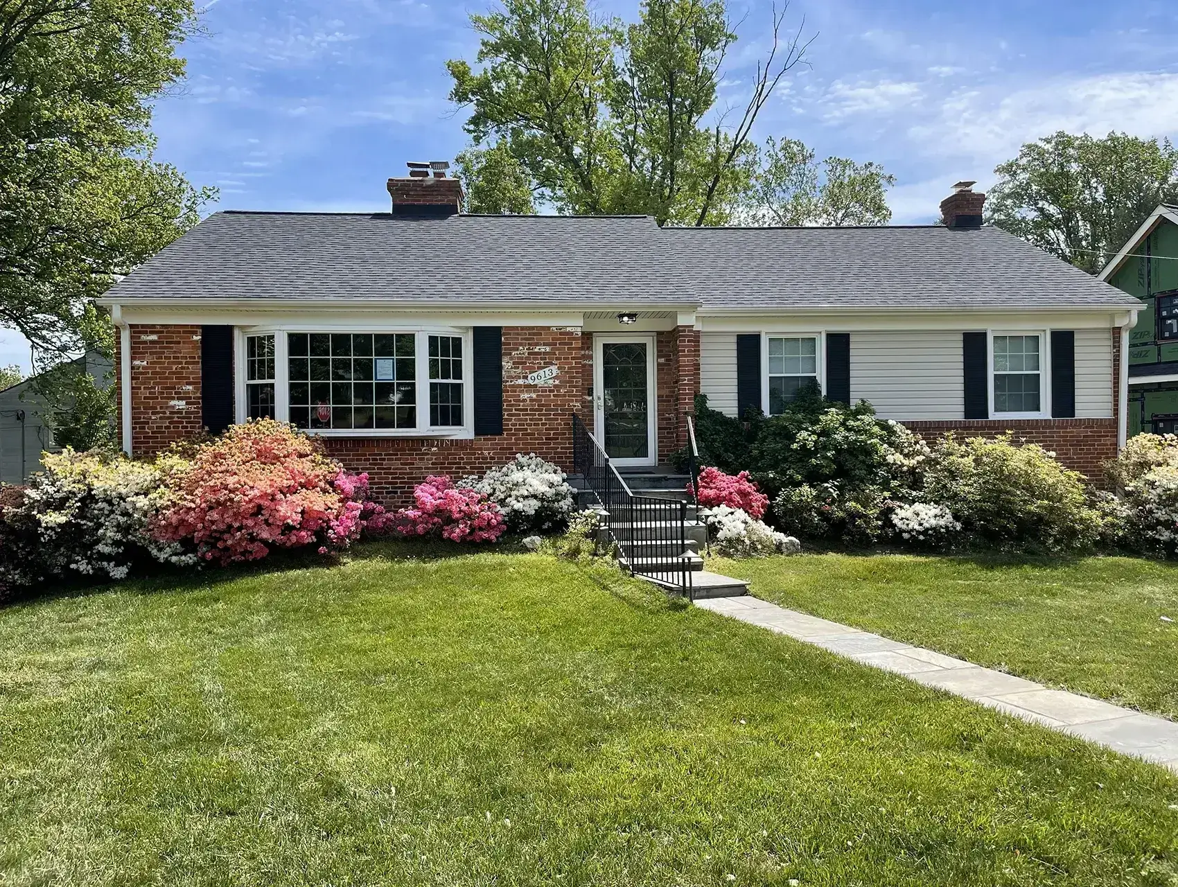 Brick house with colorful flowering bushes