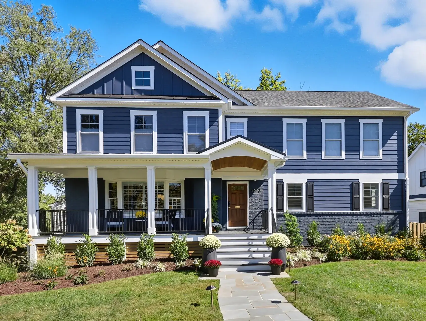 Blue two-story house with porch and walkway